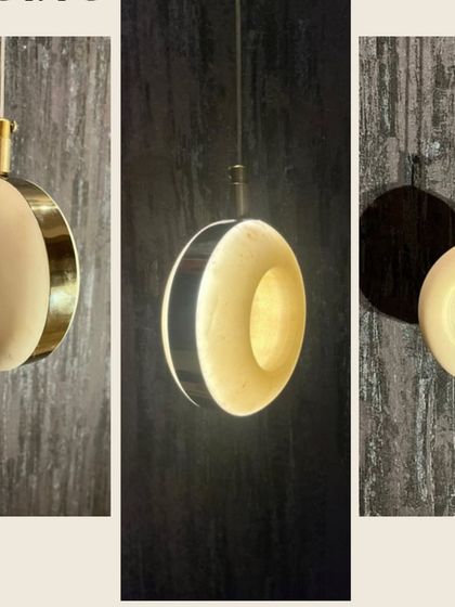 A donut-shaped pendant light made from marble with a brass accent. This modern design is shown from multiple angles to highlight its unique form.