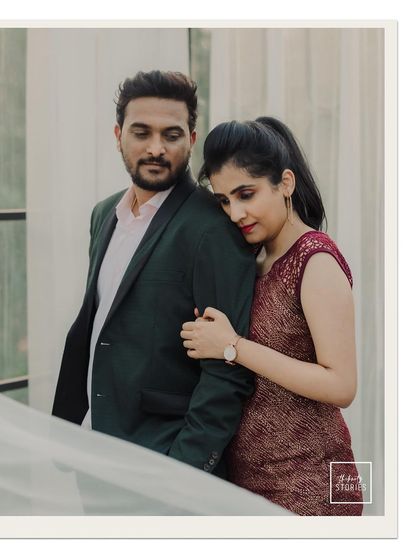 A tender and stylish couple portrait. The way she rests on his shoulder conveys a sense of comfort and deep affection in a modern setting.