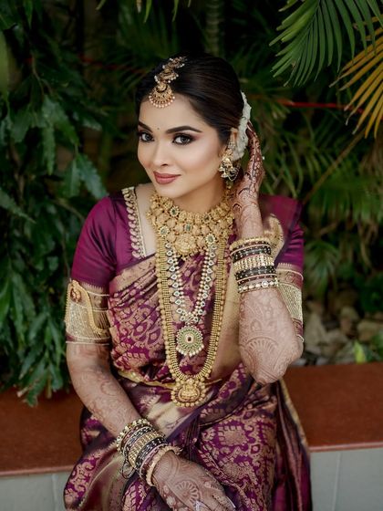 A portrait of my timeless South Indian bride, Shloka. Her makeup features a classic smoky eye and a deep lip color, perfectly complementing the rich purple of her Kanjeevaram silk saree.