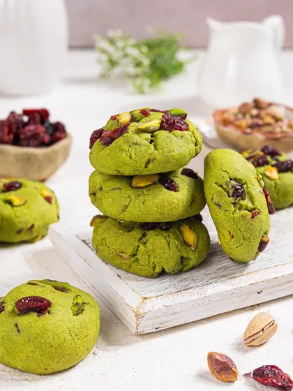 A stack of the pistachio and cranberry cookies, styled against a clean white background. This allows the vibrant green and red colours to really stand out.