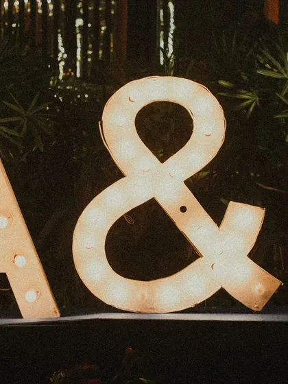 The couple's initials in glowing marquee lights add a personal and romantic touch to the decor. It's a simple yet powerful way to celebrate their union.