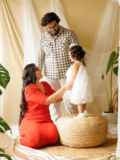 The whole family together, focused on their little girl. These interactive poses create dynamic and heartfelt family portraits that tell a story.