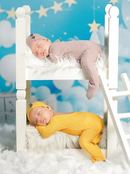 Double the blessing, double the joy. This creative setup for newborn twins, featuring a miniature bunk bed against a dreamy sky backdrop, shows my experience in safely and beautifully posing more than one little one.
