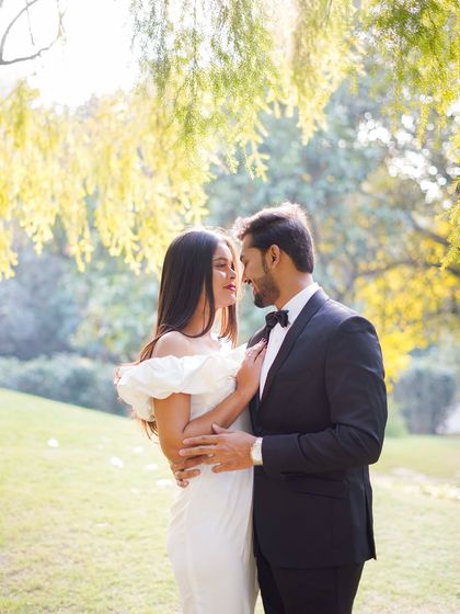 A romantic portrait under the soft, filtered light of willow trees. This kind of natural setting provides a beautiful, serene backdrop for couple photography.