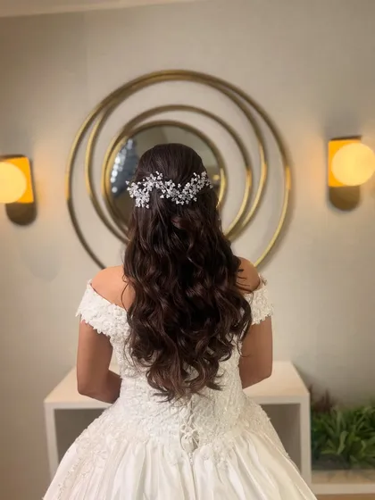 I love creating elegant hairstyles for white weddings. Here, I styled the bride's hair in soft, flowing curls and finished it with a delicate, sparkling hair vine for a touch of classic romance.