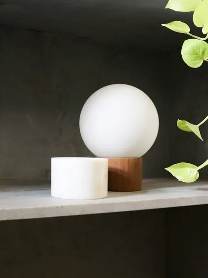 This custom-designed lamp for the DUA Villa juxtaposes a warm timber base with a light, airy white bulb. The design follows the same philosophy as the architecture, balancing earthy materials with ethereal light.