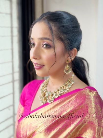 This look features a sleek ponytail, offering a more modern take on traditional saree styling.