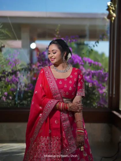 A full-length view of the party look. The elegant draping of the dupatta and the simple floral hair accessory complete the style.