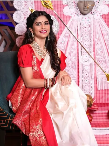 This seated portrait captures the elegance of the complete Bengali look, with makeup and hair styled to match the celebratory mood.