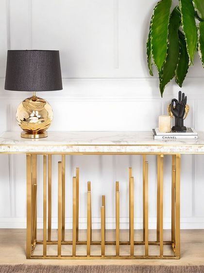 The Golden Spectra Console Table, with its unique PVD-coated steel base and marble top, provides a perfect stage for one of my sculptural gold table lamps. This pairing creates a look of modern luxury.