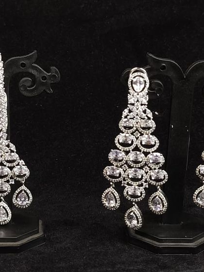 A set of long, dangling American diamond earrings with a matching maang tikka. Rent these for a glamorous reception look.