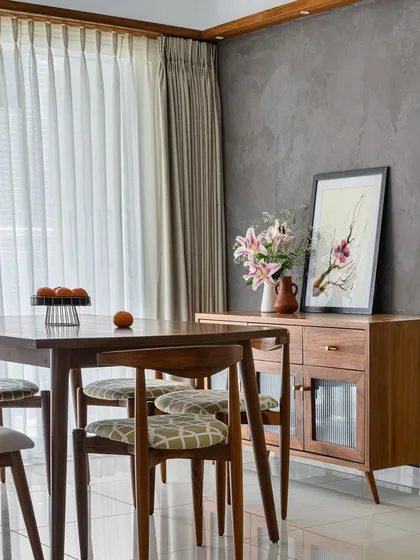 The dining area in our 'Poorna' project, featuring a custom-made crockery unit with fluted glass doors, paired with a classic wooden dining set.