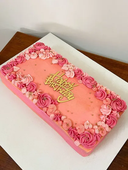 I love creating edible art for your biggest celebrations. This rectangular sheet cake was a canvas for hand-piped buttercream florals in shades of pink, making a beautiful centerpiece for a special birthday.