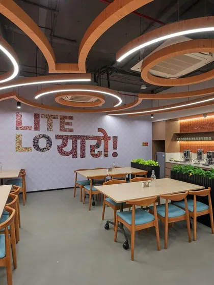 Our design for this office cafeteria channels a playful and relaxed vibe with the "Lite Lo Yaaro!" (Take it easy, friends!) wall graphic. We believe social spaces should be fun and engaging, encouraging employees to unwind and connect.
