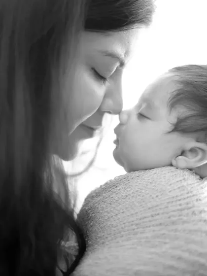 An intimate, high-contrast black and white photo capturing a tender moment between mother and child. These close-up shots are perfect for preserving the deep connection of the early days.