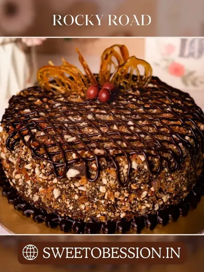 A delicious Rocky Road cake loaded with nuts and drizzled with chocolate, offering a delightful crunch.