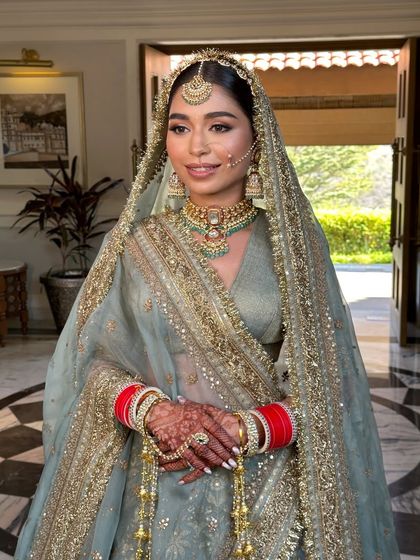 The bride with her dupatta set, her sleek hair and traditional jewelry creating a look of classic bridal beauty.