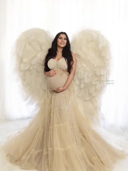 An angelic portrait featuring our large angel wings. The mother-to-be, dressed in a beautiful beige gown, looks absolutely heavenly in this ethereal studio setup.