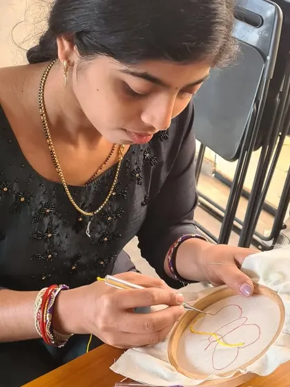 A close-up of a participant concentrating on her punch needle art. It's a craft that requires focus, which helps calm the mind and provides a break from daily worries.