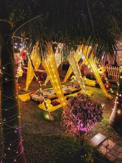 Even from a distance, the setup glows. I carefully place lighting, including wrapping it around nearby trees, to ensure the entire area feels magical and is perfect for an evening celebration.