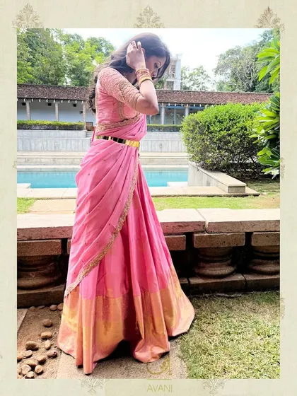A client in a lovely pink half-saree. The custom-embroidered blouse and simple gold belt create a graceful and elegant silhouette.