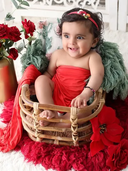 Sometimes, the most beautiful portraits come from the simplest moments. This little girl's infectious giggle and bright smile were the highlight of our session, captured in a classic setup with soft textures and a pop of red.