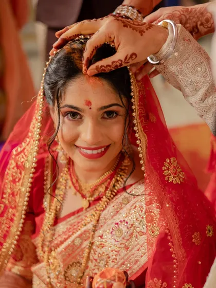 A beautiful close-up during the 'sindoor' ceremony. This intimate moment captures the bride's glowing expression and her classic red lip.