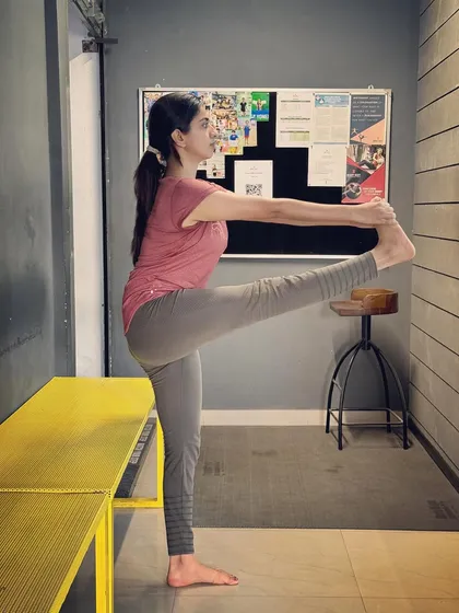 Practicing the extended hand-to-big-toe pose, or Utthita Hasta Padangusthasana. This pose challenges balance, flexibility, and concentration.