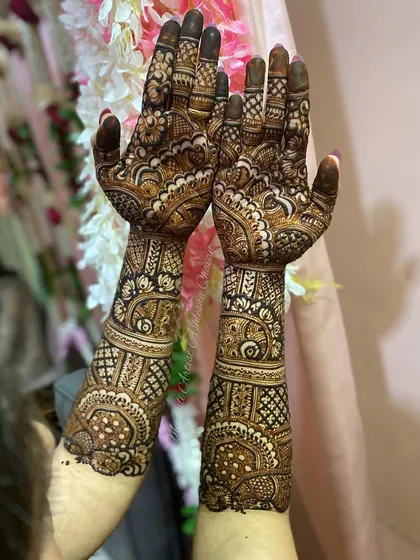 A full bridal mehendi for a happy client. The design is intricate and covers the hands and arms in a beautiful, flowing composition.
