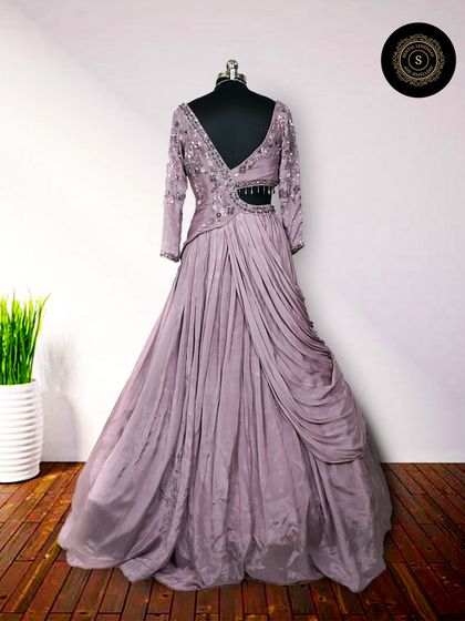 This lavender gown features beautiful draping and a stylish cutout detail at the waist. It's a modern and sophisticated choice for any evening event.