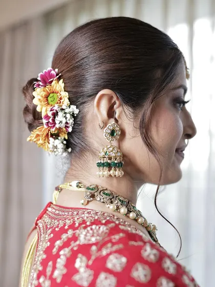I collaborate with hairstylists to ensure the entire look is cohesive. This floral bun adds a touch of freshness and tradition to the overall bridal style.