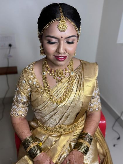 This golden Kanchipuram saree is perfectly complemented by the all-gold jewellery and a classic makeup look with a bold red lip.