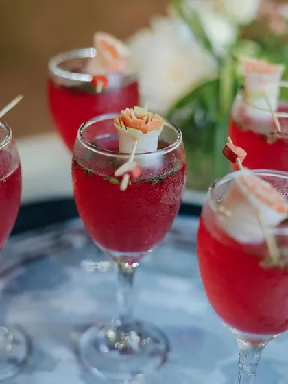 A vibrant red mocktail garnished with an edible flower. We use creative garnishes to make our drinks stand out.
