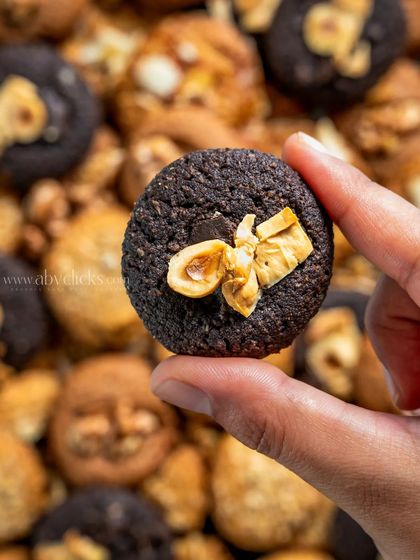 A close-up, hand-held shot of a single cookie, showing its texture and ingredients in detail.