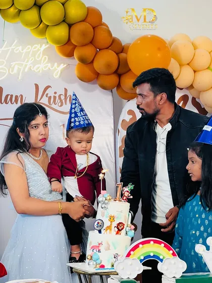 A candid moment from a first birthday party, showing the family at the cake cutting ceremony. My decorations provide the perfect backdrop for capturing these precious memories.