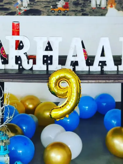 A close-up of the space-themed decor, featuring a '9' foil balloon and marquee letters spelling 'ARHAAN'. Even small details are designed to fit the theme perfectly.