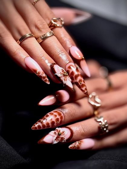 This angle highlights the sharp stiletto shape and the intricate details of the nail art.