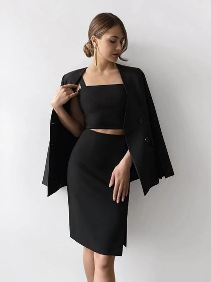 A stylish and comfortable black co-ord set featuring a pencil skirt with a side slit and a matching square-neck crop top. The blazer draped over the shoulders completes the look.