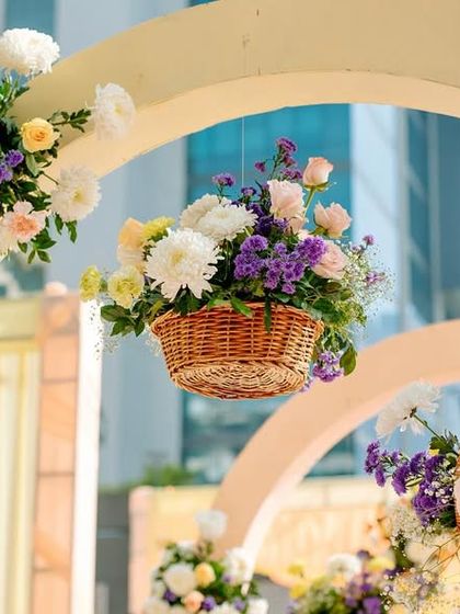 A close-up of the floral details on the entrance arches, with hanging wicker baskets filled with flowers adding a charming, rustic touch.