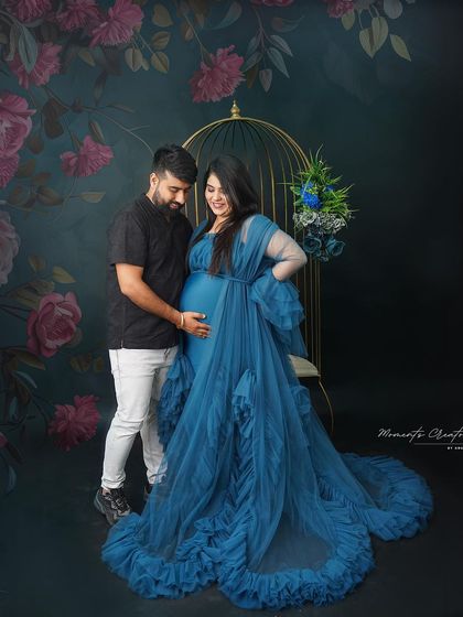 A gentle moment between the couple. The dad-to-be places a hand on the baby bump, connecting with his unborn child in this beautiful floral setup.