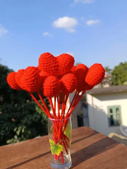 A vase full of red heart flower stems.