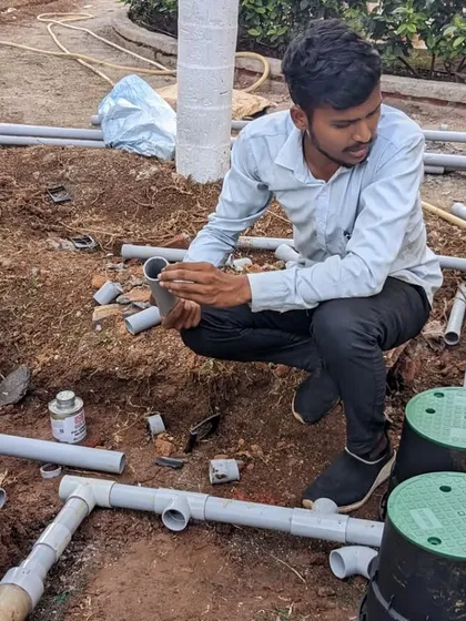 I am overseeing the connection of pipes to the main valve boxes, a critical step in the irrigation setup.