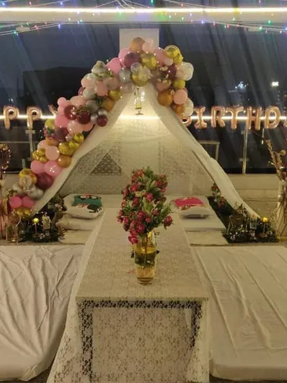 A nighttime view of the birthday cabana, where the lights create a warm and inviting glow. This setup is ideal for a surprise birthday dinner under the stars.