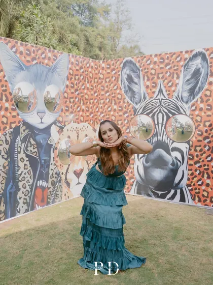 A guest enjoying the interactive photo wall at the 'Afro Jungle Carnival'. We love creating decor that is not just beautiful but also engaging for everyone.