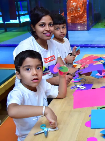 An instructor helps two young boys with their paper crafts. My workshops provide a supportive environment where kids get hands-on guidance to bring their creative ideas to life.