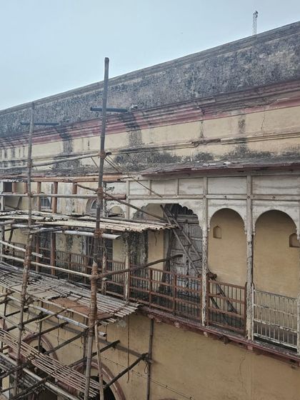 The haveli facade with traditional bamboo scaffolding, a common sight during the careful, hands-on process of heritage restoration.