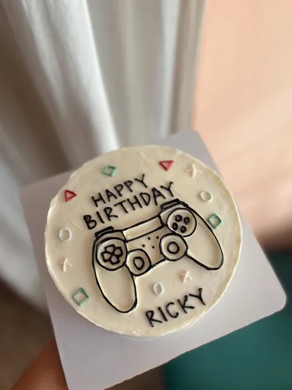 For the gamer in your life. This bento cake features a hand-drawn PlayStation controller, perfect for a birthday celebration.