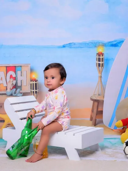 Our 'Beach Baby' theme brings the shore to the studio. I use a beach-themed backdrop, a miniature deck chair, a surfboard, and other fun props to create a sunny and playful setting for your child.