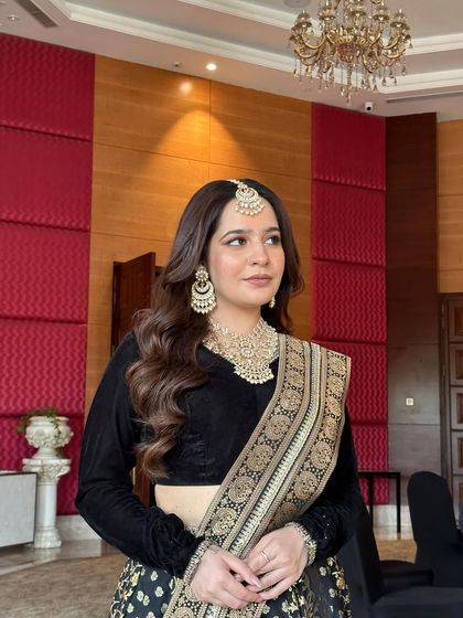 If there's anything that can match her elegance, it's our jewellery. A client looking stunning in a black and gold saree paired with a full polki necklace set.