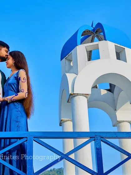 A tender forehead kiss on the balcony of our Santorini set, with the bright blue sky creating a picture-perfect backdrop.